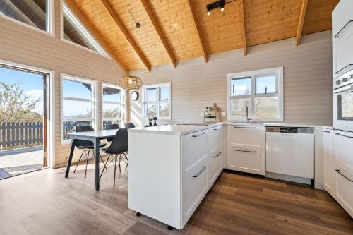 a kitchen with white cabinets and a table with chairs at Cosy Cabin on the Golden Circle in Selfoss