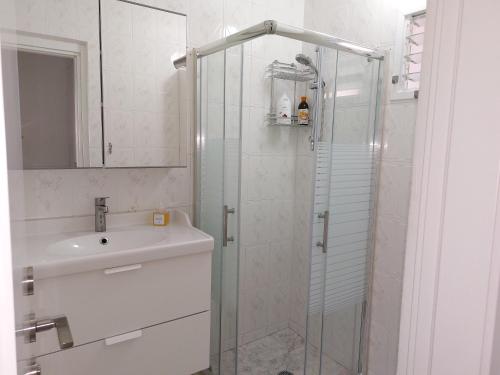a bathroom with a glass shower and a sink at Sanny Bay in Qiryat Yam