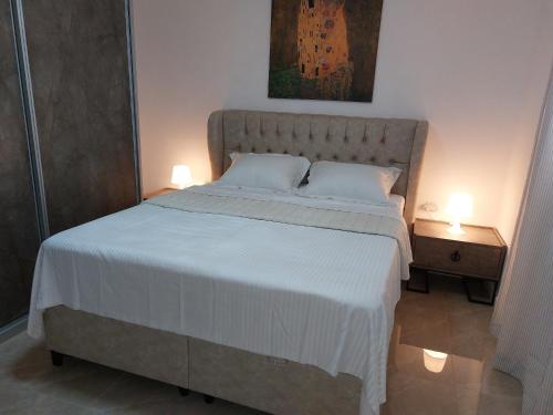 Qiryat Yam的住宿－Sanny Bay，一间卧室配有一张大床,上面有两盏灯
