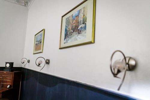 a room with three pictures on the wall and aperature at Hotel Du Dauphiné in Lyon