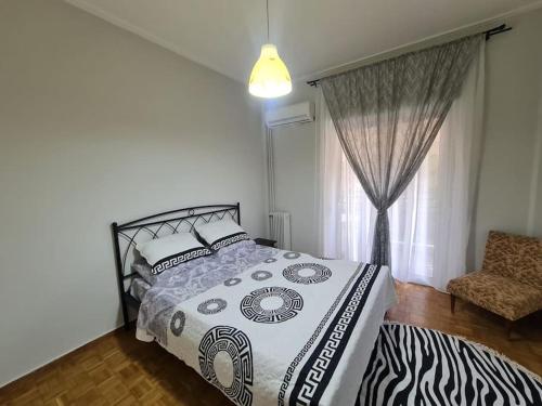 a bedroom with a bed and a chair and a window at Sunny Dream House in Piraeus