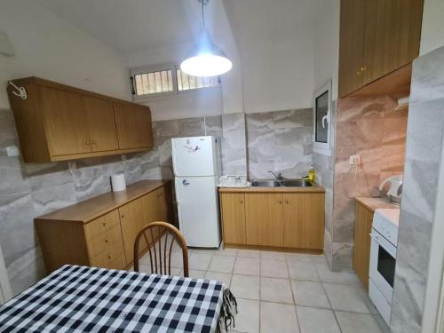 a kitchen with a table and a white refrigerator at Sunny Dream House in Piraeus
