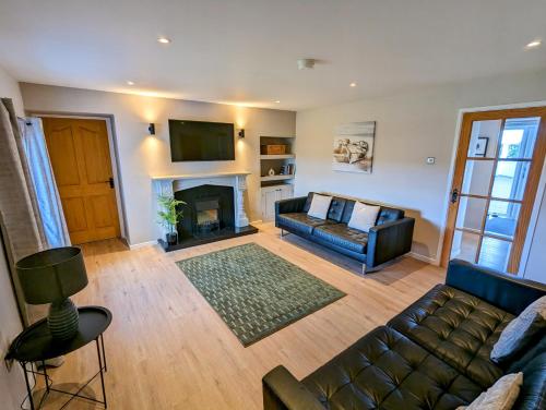 a living room with a couch and a fireplace at Tyrella Cottage in Tyrella