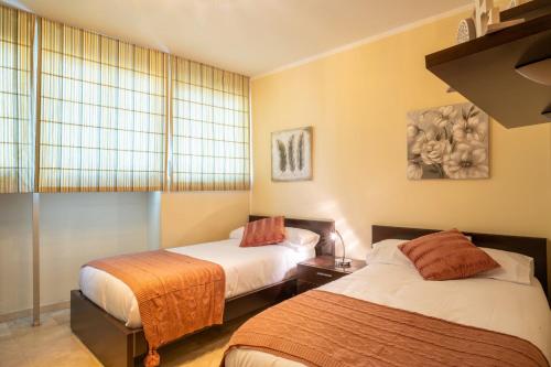 サンタクルス・デ・テネリフェにあるCentrico apartamento en Santa Cruz de Tenerifeのベッド2台と窓が備わる客室です。