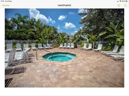 a patio with chairs and a pool and a bunch ofitures at Mickey Holiday Home a Windsor Palms Villa in Kissimmee