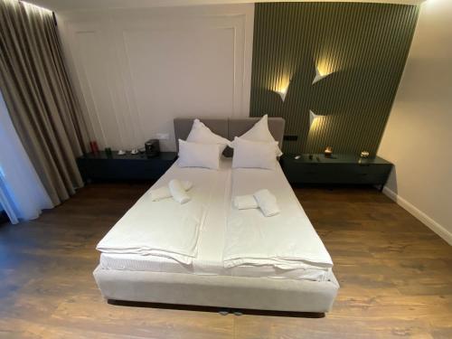 a bed with white sheets and pillows in a room at Casa Viilor in Chişinău