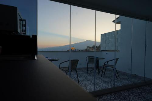 een kamer met 2 stoelen en een tafel op een balkon bij Opuntia Charming Rooms in Taormina