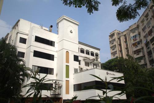 Un edificio bianco con un orologio sopra. di Kings Hotel Egmore a Chennai