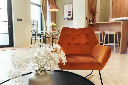 a living room with a leather chair and a table at The Middle House in Satu Mare