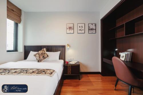 a hotel room with a bed and a desk and a table at Home suites -Natural light -Projector -Spacious - 2BR incenter in Hanoi