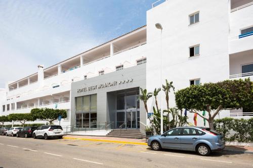 un edificio blanco con coches estacionados frente a él en Hotel Best Mojácar, en Mojácar