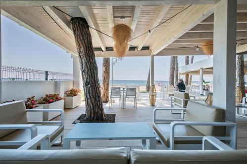 a patio with tables and chairs and the beach at Hotel Best Terramarina in La Pineda