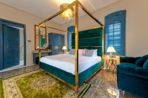 1 dormitorio con cama con dosel y sofá en Clouds Nest By Aanvis Inn en Ooty