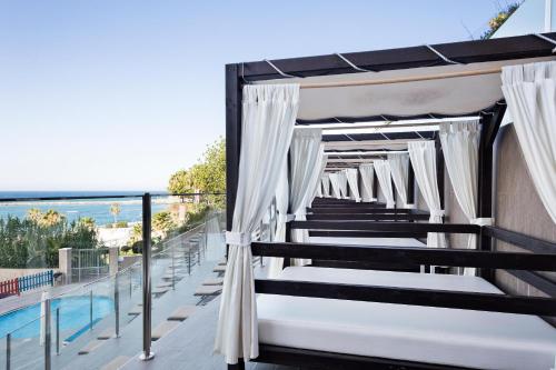 a canopy bed on a balcony with a view of the ocean at Hotel Best Benalmadena in Benalmádena