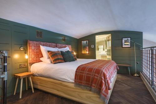1 dormitorio con 1 cama grande y paredes verdes en Shirehall Apartments, en Holt