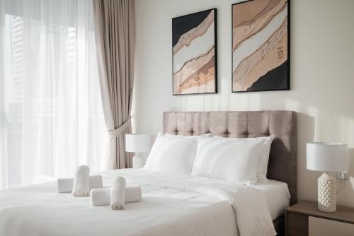 a white bedroom with a large bed with white pillows at 2BR 1 Residences Zabeel with Sleeps 5 - Luxury Stay in Dubai