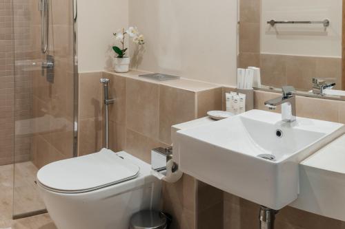 a bathroom with a sink and a toilet and a shower at LUXE 2BR at 1 RESIDENCES WASL NEAR METRO STATION in Dubai