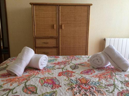 dwa ręczniki na łóżku z komodą w obiekcie Apartamento en la Playa de Somo. w mieście Somo