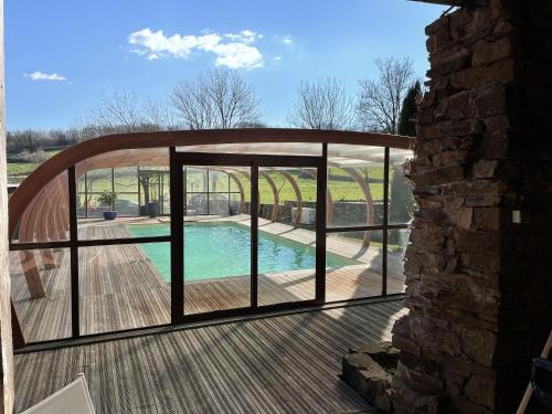 Cette chambre offre une vue sur une terrasse dotée d'une piscine. dans l'établissement Les maisons du Salvignol, 