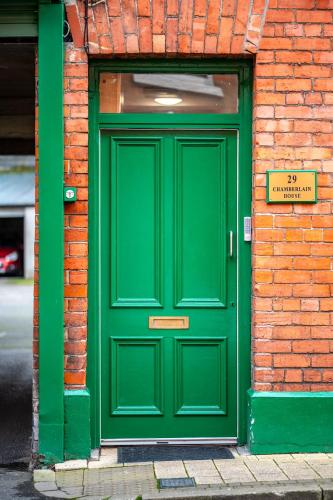 a green door on the side of a brick building at Chamberlain House in Derry Londonderry