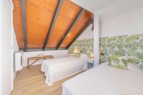 - une chambre avec deux lits et un plafond en bois dans l'établissement Doña Elvira. Las Terrazas, à Malaga