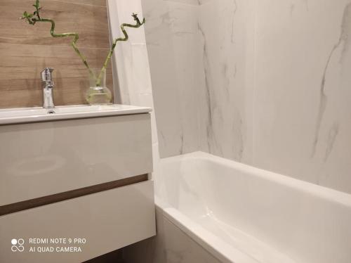 La salle de bains est pourvue d'un lavabo et d'une baignoire blanche. dans l'établissement Studi'Hotel cœur Sablettes CLIM parking H24 total autonomie, à La Seyne-sur-Mer