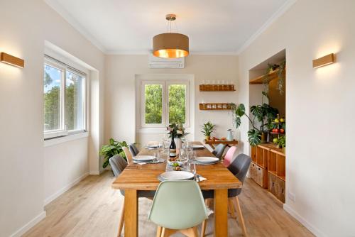 a dining room with a wooden table and chairs at Familienparadies nahe Strand - Baumhaus & Tiere in Colares