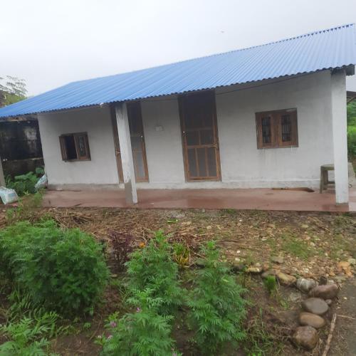 a small white house with a blue roof at EcoPark in Meghauli