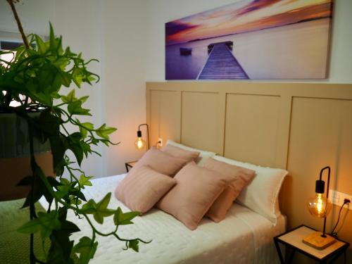 a bedroom with a bed with pillows and a painting at Apartamento en Bilbao in Bilbao
