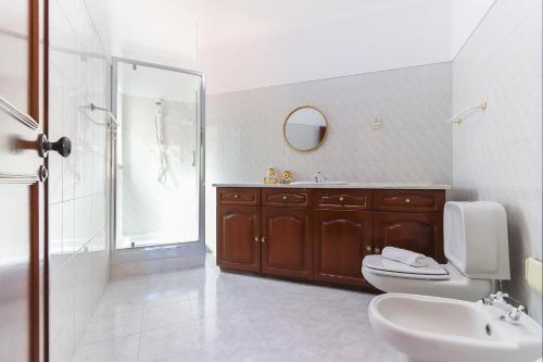 a bathroom with a toilet and a sink and a shower at Sintra Classic Villa with Pool by Homing in Sintra