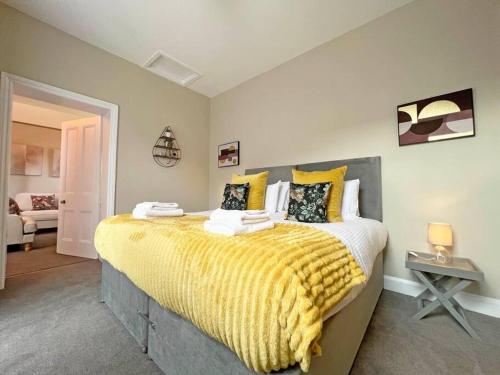a bedroom with a large bed with a yellow blanket at 2-Bed Victorian Elegance in Chester