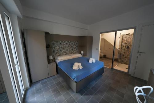 a bedroom with a blue bed with towels on it at Opuntia Charming Rooms in Taormina