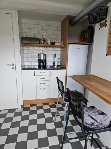 una cocina con suelo a cuadros en blanco y negro en Brahe 65, en Gränna