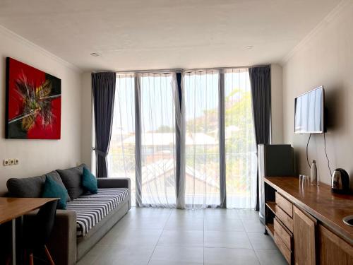 a living room with a couch and a large window at Komodo Suites Downtown in Labuan Bajo
