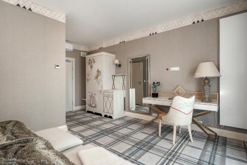 a bedroom with a desk and a chair in a room at Aries Hotel & SPA Szczyrk in Szczyrk