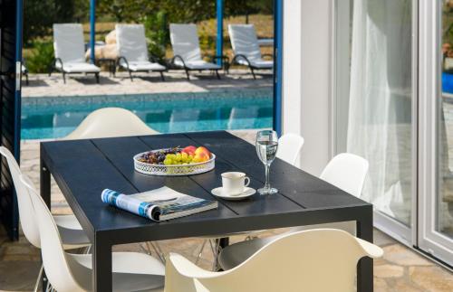 a black table with a bowl of fruit and a glass of wine at Holiday home Blue Sky in Zaostrog