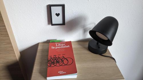 a black lamp sitting on a table next to a book at Dynamic Bike Home in Curtea de Argeş