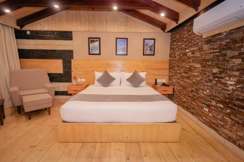 a bedroom with a bed and a brick wall at Regenta Resort MARS Valley View Shoghi in Shimla