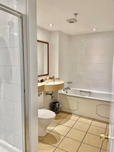 a bathroom with a toilet and a sink and a bath tub at Grand Hotel Sunderland in Sunderland