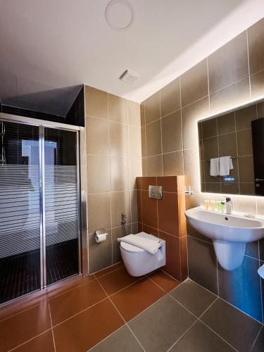 a bathroom with a toilet and a sink and a shower at Celino Hotel in Amman