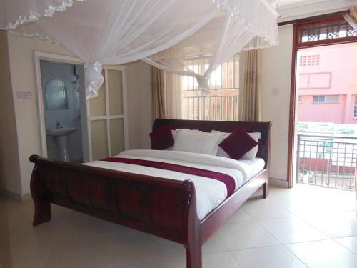 a bedroom with a large bed with a canopy at Psalms Motel in Entebbe