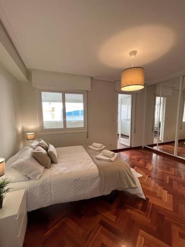 1 dormitorio con 1 cama grande y suelo de madera en Céntrico apartamento con terraza integrada, en Vigo