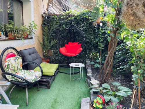 a small garden with chairs and a swing at City Garden Apartments in Bucharest