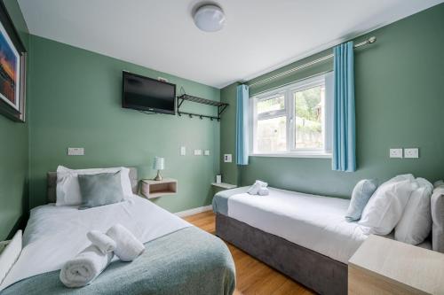2 Betten in einem Zimmer mit grünen Wänden in der Unterkunft Chamberlain House in Derry Londonderry