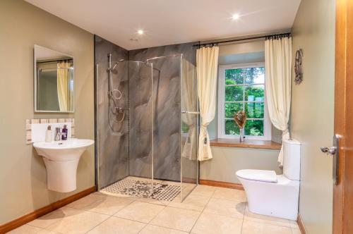 a bathroom with a shower and a toilet and a sink at The Jaw Barn in Milngavie