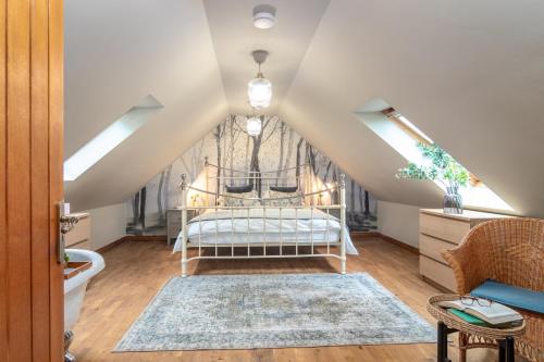 ein Schlafzimmer mit einem Bett im Dachgeschoss in der Unterkunft The Jaw Barn in Milngavie