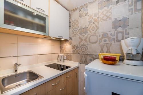 a small kitchen with a sink and a counter at Apartments Nadica in Baška