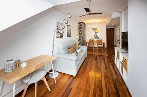 a living room with a couch and a table at Atico Martina Centro in Gijón