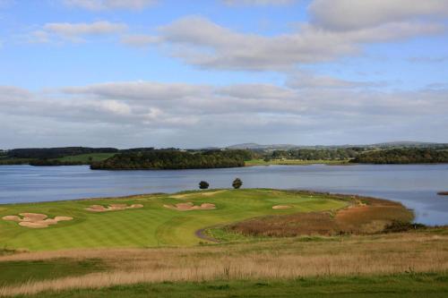 a golf course with a view of a lake at Escape Ordinary at Castle Hume in Enniskillen