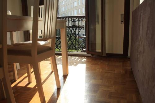 Una habitación en mi casa - Centro de Santander في سانتاندير: طاولة وكرسي في غرفة مع شرفة